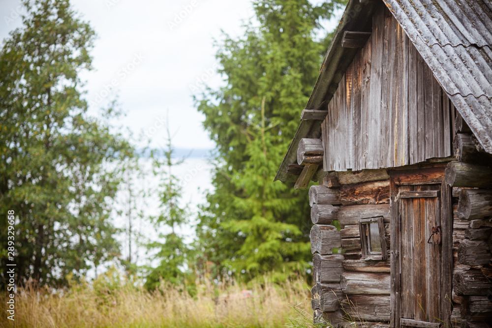 Landscape with an old log bath. Ancient Karelian bath on the shore of Shotozero. Sauna from a log on the lake. Landscape with an old log bath. Ancient Karelian bath on the shore of Shotozero. Sauna from a log on the lake.