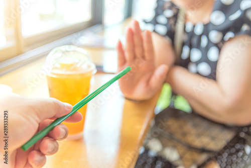 Close up hand holding straw and say no for plastic drinking straw. Concept related to banned plastic drinking straws, environmental concerns. x photo