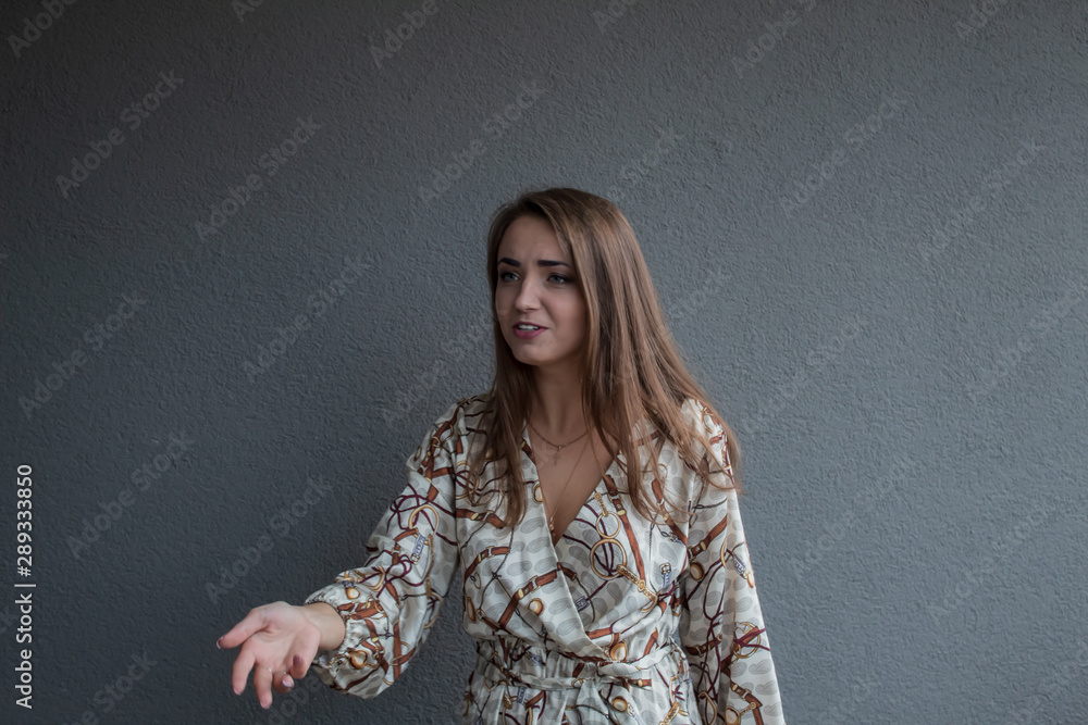A young, beautiful, blue-eyed girl in a dress asking for something by reaching out. A young, beautiful, blue-eyed girl in a dress asking for something by reaching out.