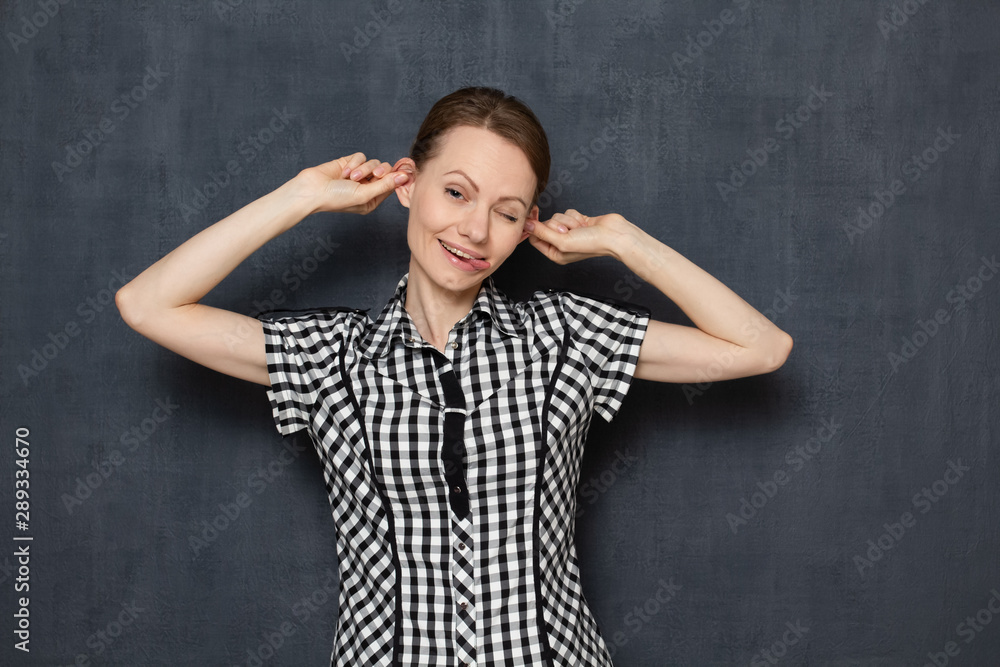 Portrait of funny girl touching ears and sticking out tongue Portrait of funny girl touching ears and sticking out tongue