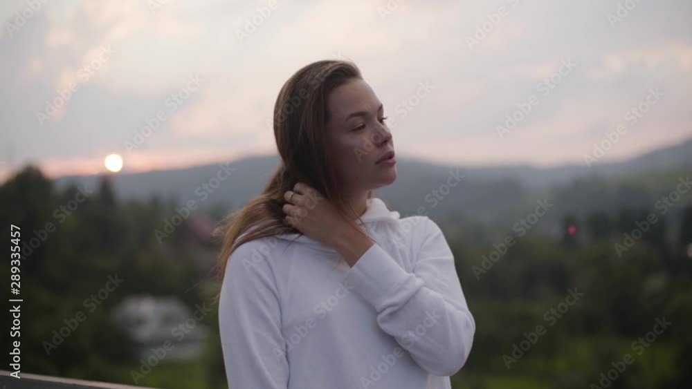 Attractive fashionable woman posing while standing in front of beautiful landscape with mountains. Connection with wild nature. Leisure outdoors, active lifestyle. Tourism, traveling Attractive fashionable woman posing while standing in front of beautiful landscape with mountains. Connection with wild nature. Leisure outdoors, active lifestyle. Tourism, traveling