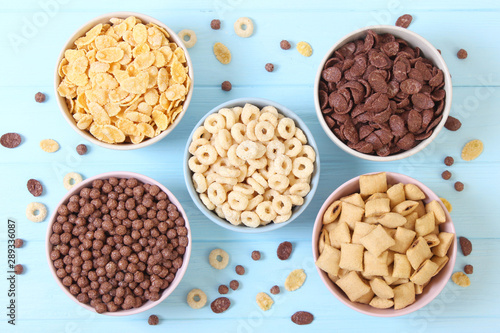 Different types of breakfast cereals on a colored background top view.