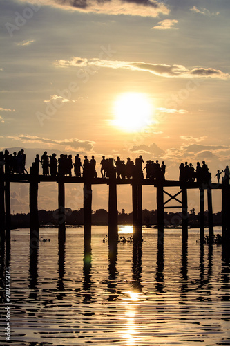 Sunset with silhouette of people walking on Bridge U-Bein in the evening, Amarapura, Mandalay, Myanmar