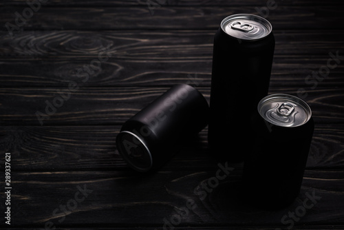 black cans of beer on wooden table with copy space