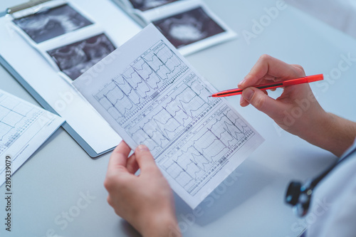 General practitioner examines electrocardiogram of patient during a health check and medical consultation. Healthcare and medicine. Diagnosis and treatment of the disease