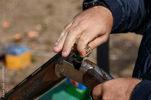 Charging a hunting rifle. Male hunter charges a double-barreled shotgun rounds. Male with a gun, rifle