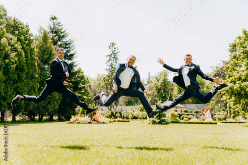 Three guys hang in the air while jumping