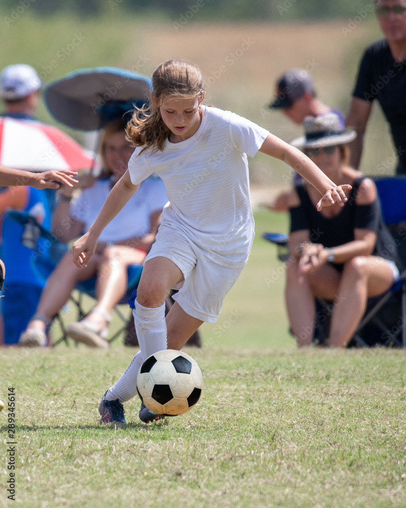 Young athletic teen girl playing in a soccer game