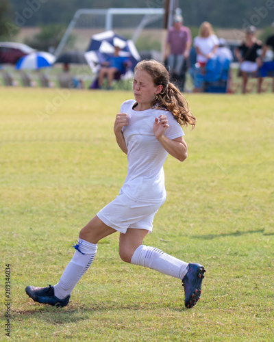 Young athletic teen girl playing in a soccer game