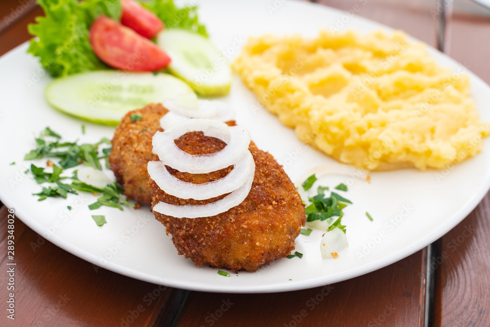 mashed potatoes with cutlet and salad on a white plate close-up mashed potatoes with cutlet and salad on a white plate close-up