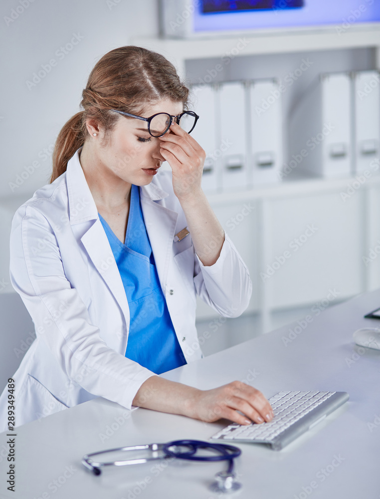 Young female doctor tired after working with computer Young female doctor tired after working with computer