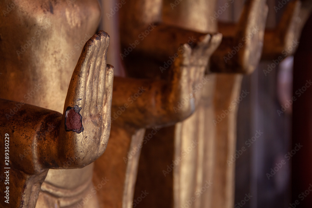 Aged time-worn hands of old bronze Buddha statues in the dark temple. Aged time-worn hands of old bronze Buddha statues in the dark temple.
