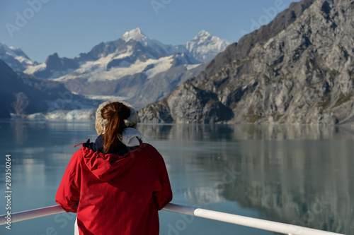 The wonders of nature, a young woman looks out at a Glacier in the distance. 