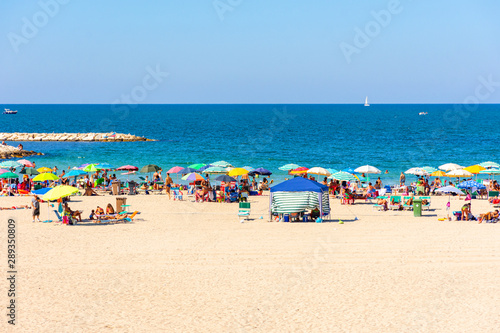 View of a beach with people bathing and sunbathing © benny