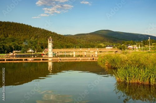 Fototapeta Naklejka Na Ścianę i Meble -  Lake in the mountain valley, swimming pool with a lookout tower.