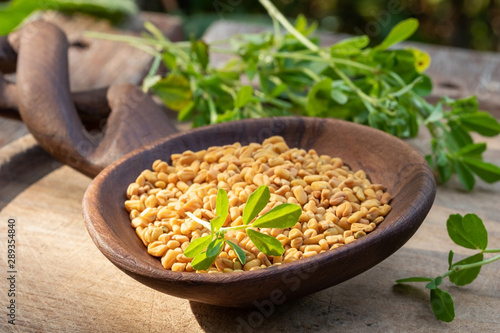 Foto Fenugreek seeds on a wooden spoon on a table