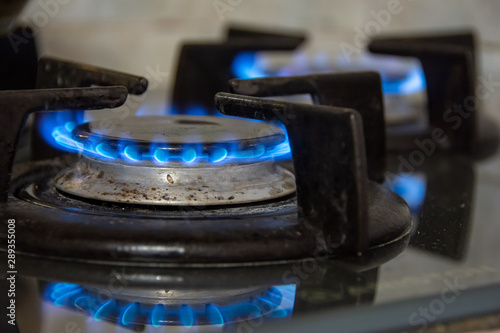 Gaz brûlant avec des flammes bleues sur les brûleurs d'une cuisinière à gaz. Concept d'empreinte carbone, de gaspillage d'énergie et de prix du gaz naturel sur le marché