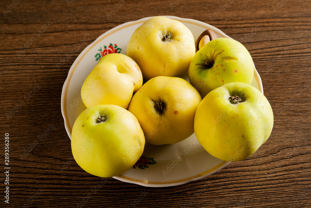 green apples in a white plate on a table green apples in a white plate on a table