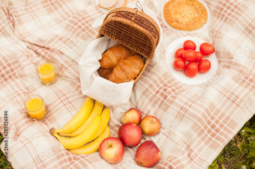 Croissant basket and fruit picnic outdoors in the park