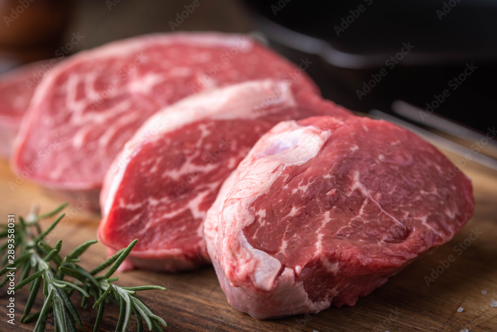 raw beef tenderloin on wooden cutting board raw beef tenderloin on wooden cutting board