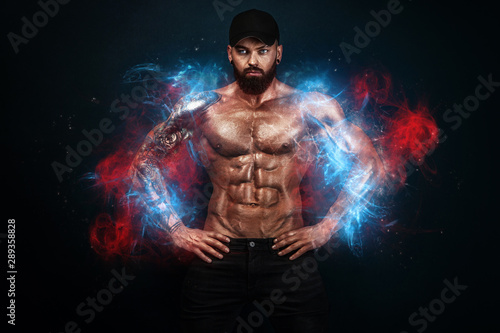 Strong and fit man bodybuilder. Sporty muscular guy. Spot and fitness motivation. Man on fire like a phoenix.