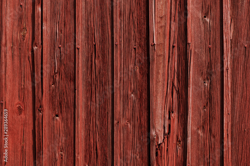 Red old grunge wood vertical panels on a rustic barn