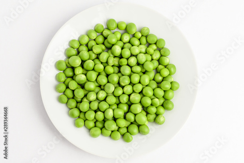 Wallpaper Mural Fresh organic green peas on a round white plate isolated on white, top view, with space for text Torontodigital.ca