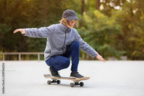 Skater girl on skatepark moving on skateboard outdoors. Copy space