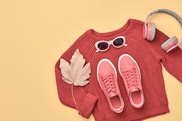 Hipster DJ trendy colorful autumn Outfit. Fall fashion minimal Flat lay. Red jumper, Stylish sneakers, headphones.Creative Woman Clothes Accessories layout, fall Girl fashionable autumnal orange color