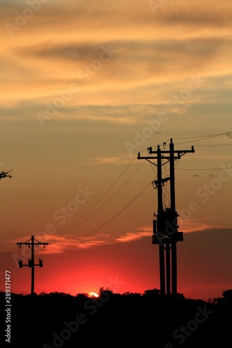 Kansas Sunset with Power Lines and Transformers on a pole.