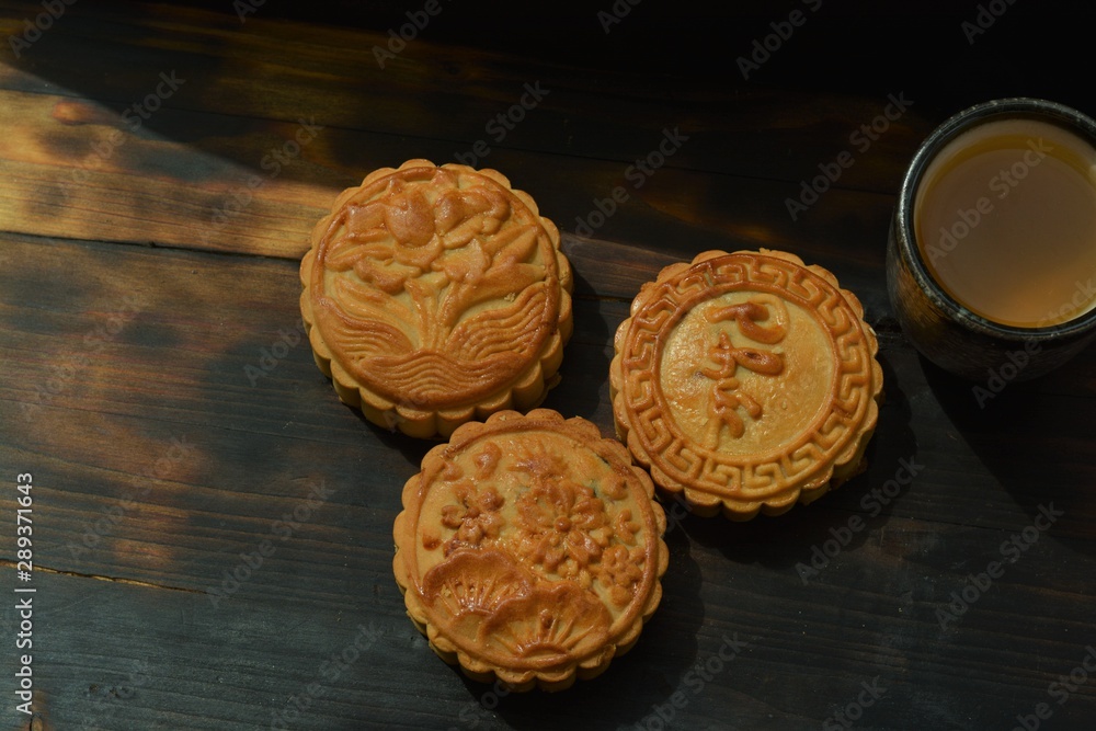 chinese moon cake on a wooden table and a black background chinese moon cake on a wooden table and a black background