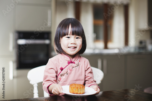 toddler girl eating moon cake and celebrating Mid Autumn festival