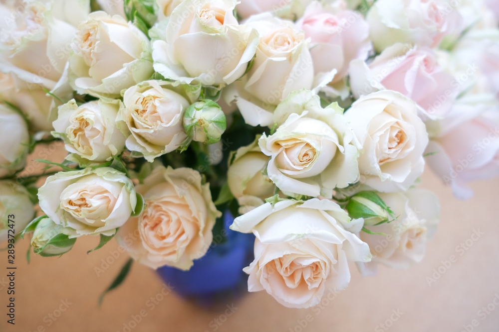 A bouquet of fresh tea and gently pink roses on a beige background. A bouquet of fresh tea and gently pink roses on a beige background.