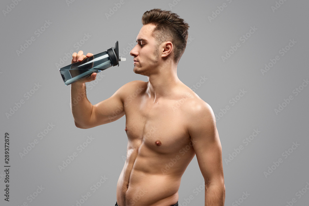 Muscular man drinking fresh water Muscular man drinking fresh water