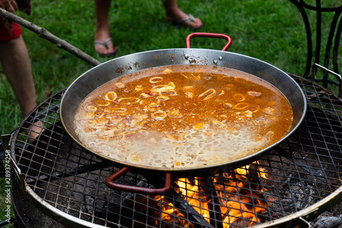 Preparando paella de marisco con fuego de leña photo