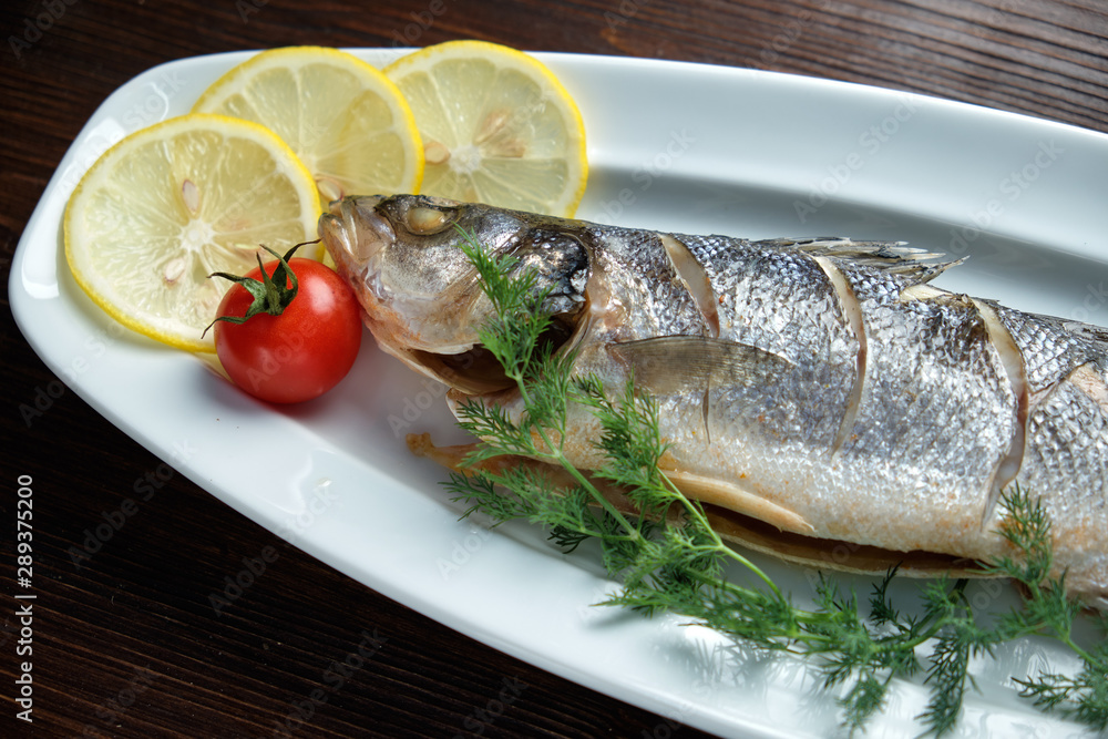 Grilled fish with a side dish and vegetables. restaurant menu Grilled fish with a side dish and vegetables. restaurant menu