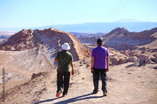 Two men walking at the top of mountain. Atacama desert, Chile, Andes mountains 