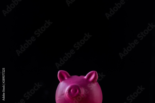 pink toy piggy bank isolated on black with copy space