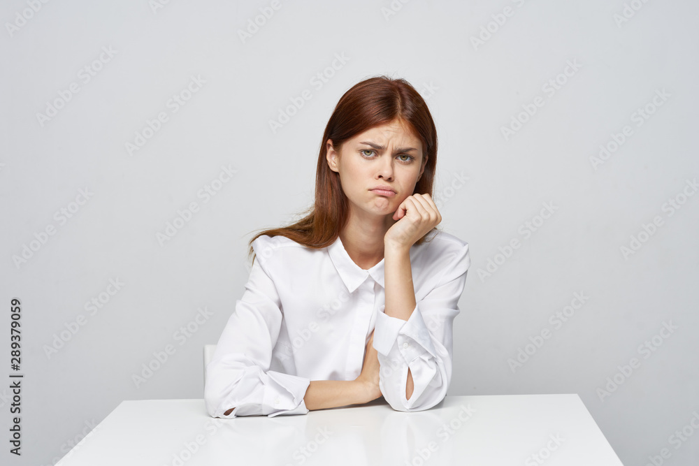 young woman sitting at desk and talking on phone young woman sitting at desk and talking on phone