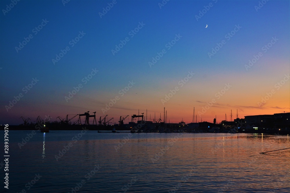 silhouettes of harbor cranes in the evening in Mangalia city - Romania