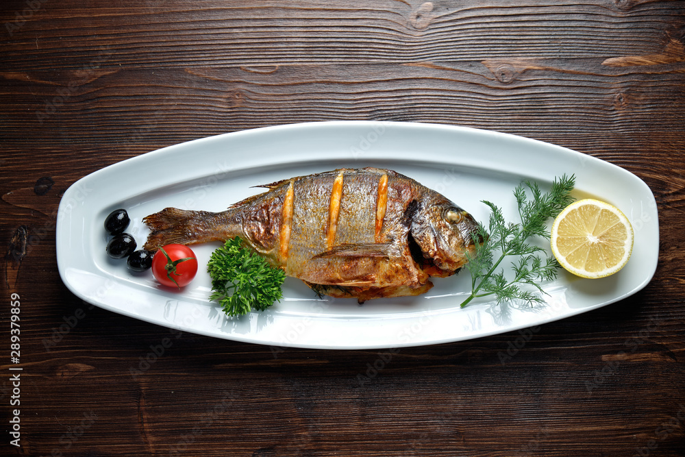 Grilled fish with a side dish and vegetables. restaurant menu Grilled fish with a side dish and vegetables. restaurant menu
