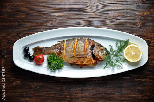Grilled fish with a side dish and vegetables. restaurant menu
