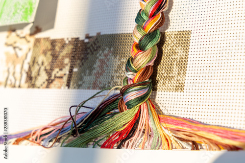 Multucolored threads made into a braid with white canvas background