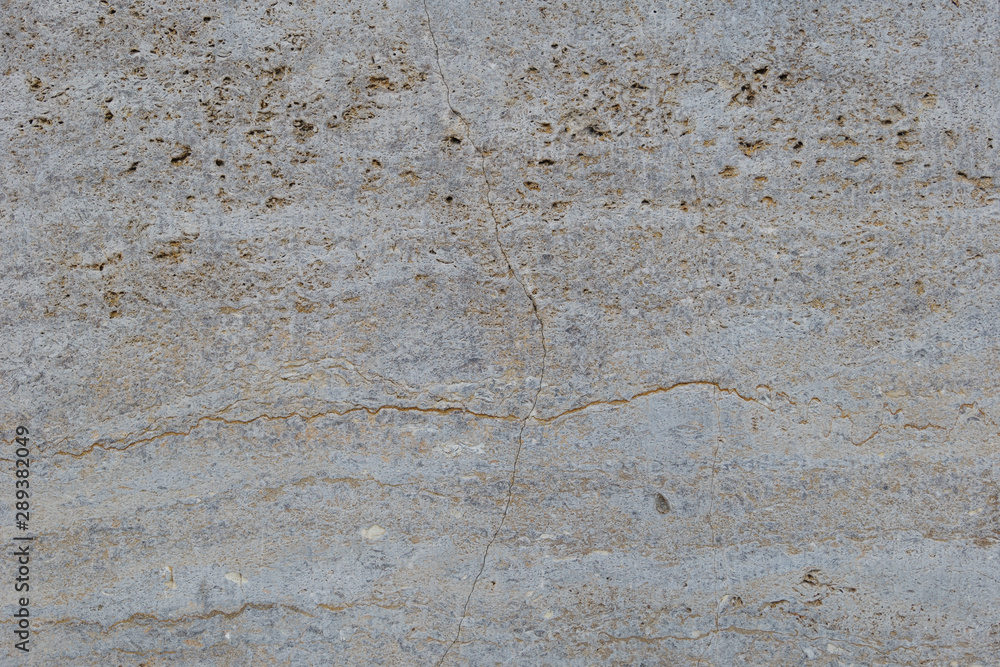 Rough white natural stone travertine with small random cavities. Limestone building material. 