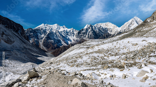 Snow covered mountain peaks in Himalayas, Nepal during bright sunny day with blue sky.