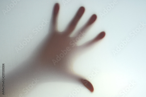 Photography Mano detras de una tela clara, expresando panico