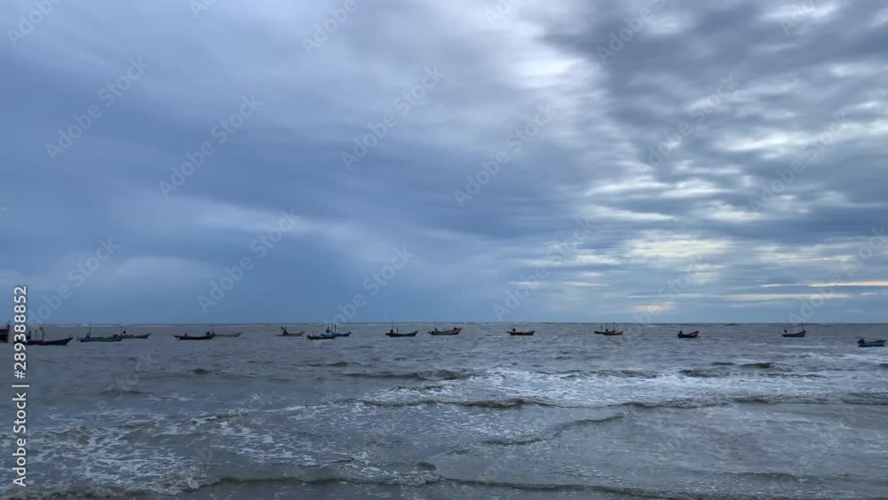 A group of fishing boats floating on the sea with rain clouds. low light A group of fishing boats floating on the sea with rain clouds. low light