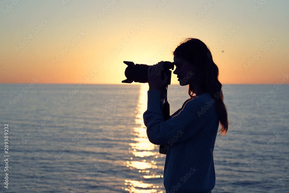 woman silhouette of a photographer at sunset woman silhouette of a photographer at sunset