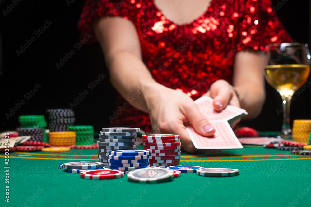 A girl in an evening red dress plays in a casino and draws cards. Gambling business casino