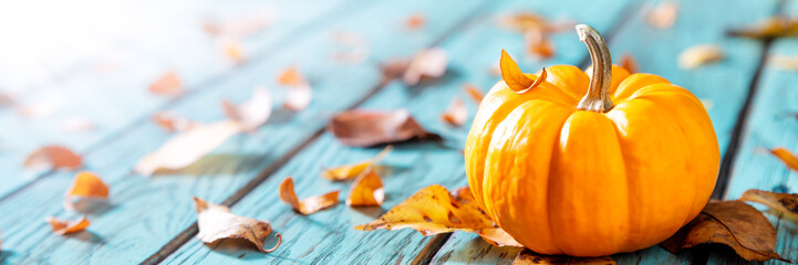 Autumn Background - Mini Pumpkin On Rustic Blue Table With Leaves And Sunlight